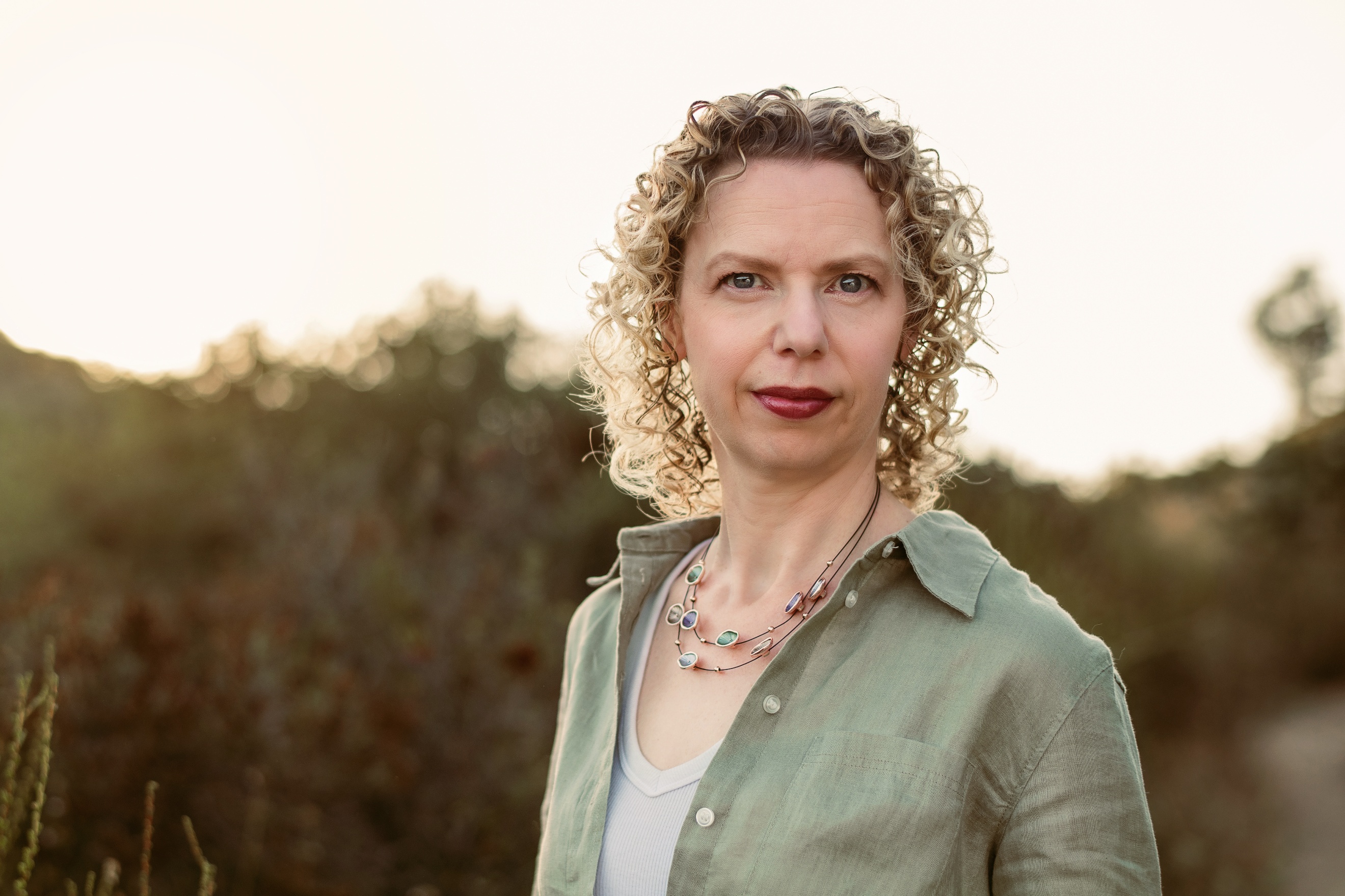 A person with curly hair wearing a green shirt

AI-generated content may be incorrect.